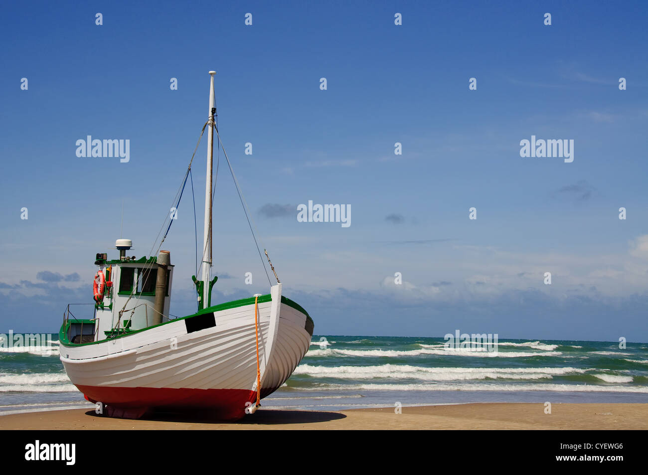 A fishingboat is lying on a sandy beach Stock Photo - Alamy