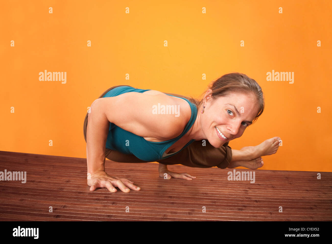 Smiling Caucasian woman performs yoga on a wooden mat Stock Photo - Alamy