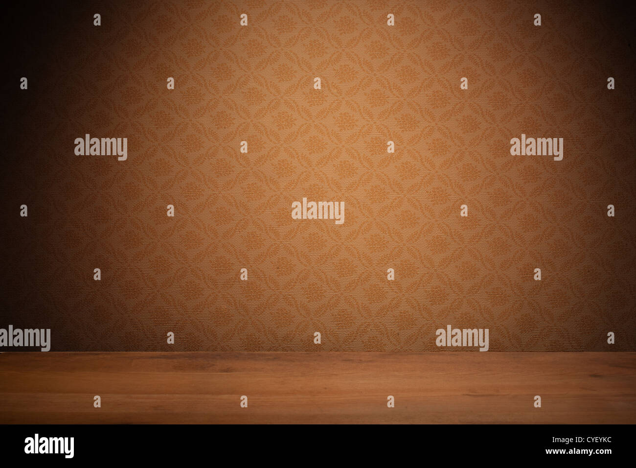 Vintage textured brown wallpaper with heavy vignetting over a wooden floor, empty with copyspace. Stock Photo