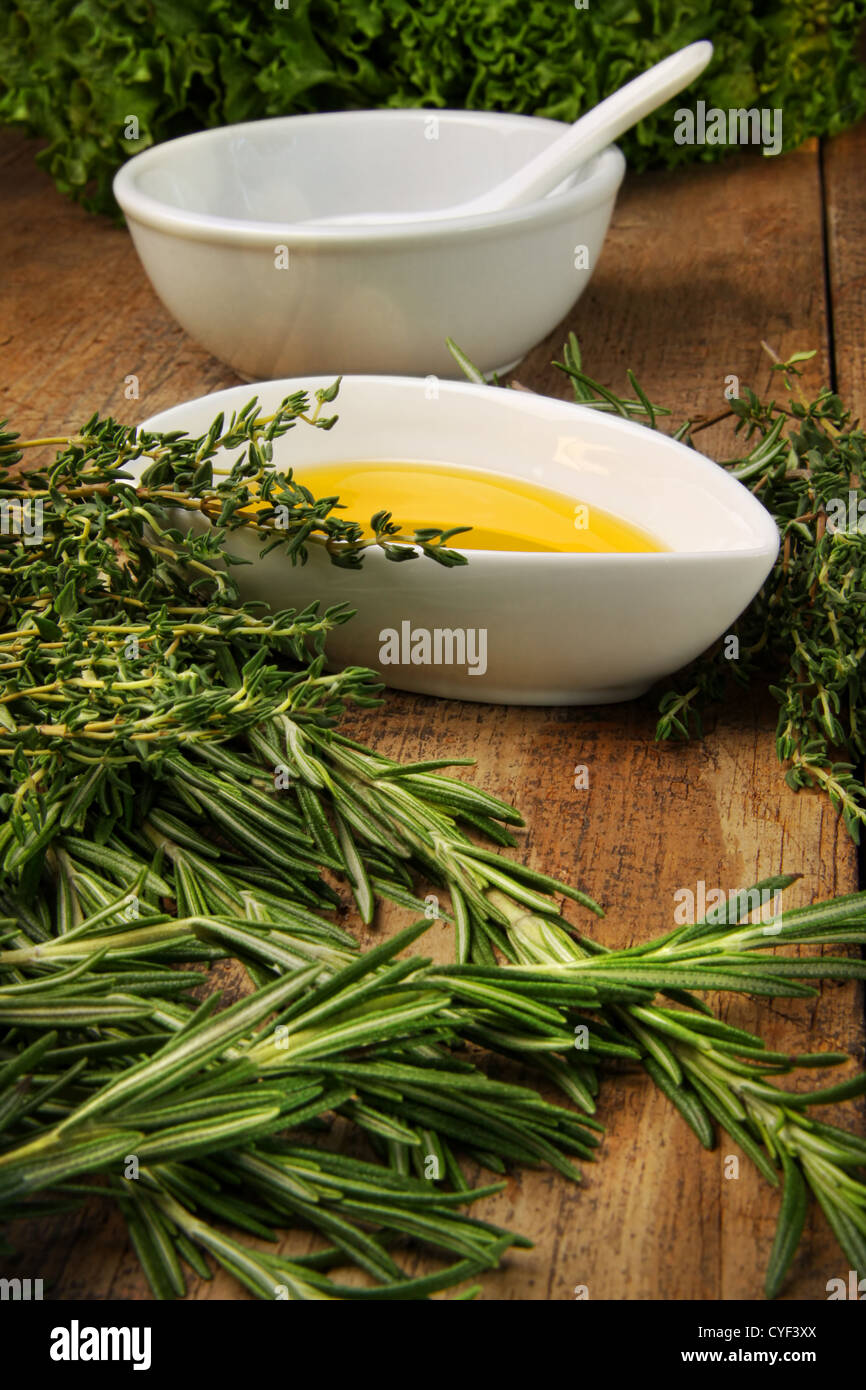 Assorted fresh herbs with olive oil on wood table Stock Photo Alamy