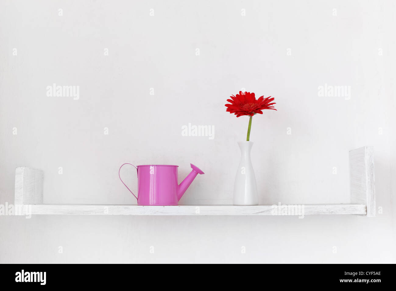 Decorative shelf on white wall with flower ina vase on it Stock Photo