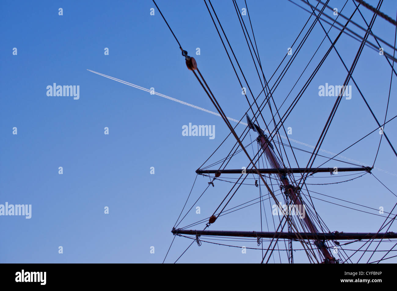 Ship mast with airplane trace on background Stock Photo