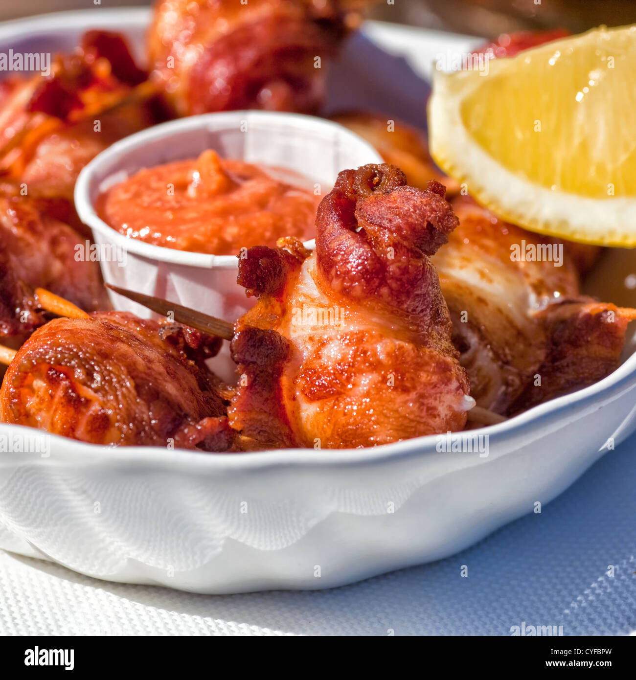 Deep fried bacon wrapped scallops with seafood sauce and lemon Stock