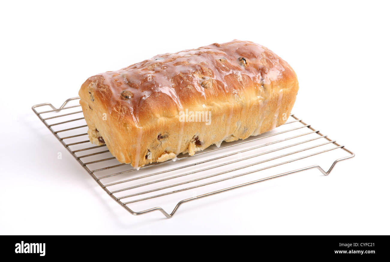 A loaf of homemade raisin bread decorated with an icing sugar glaze and