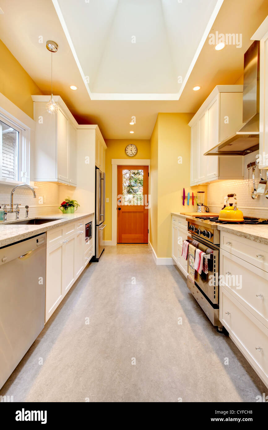 Yellow And White Bright Kitchen With Skylight And Grey Floor Stock