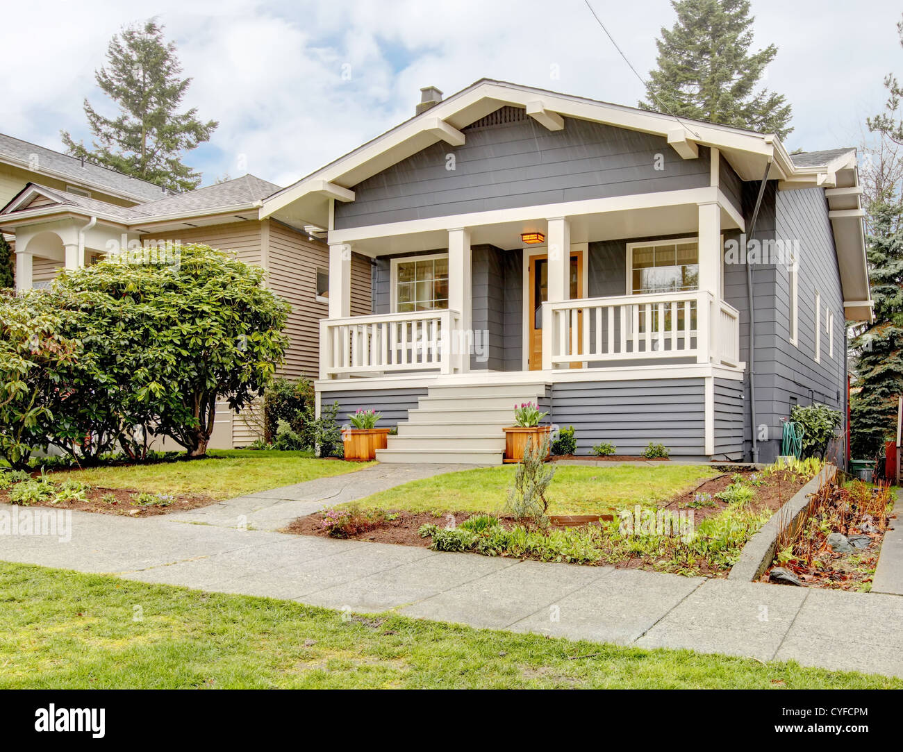 Blue grey smal craftsman style house with white porch Stock Photo - Alamy