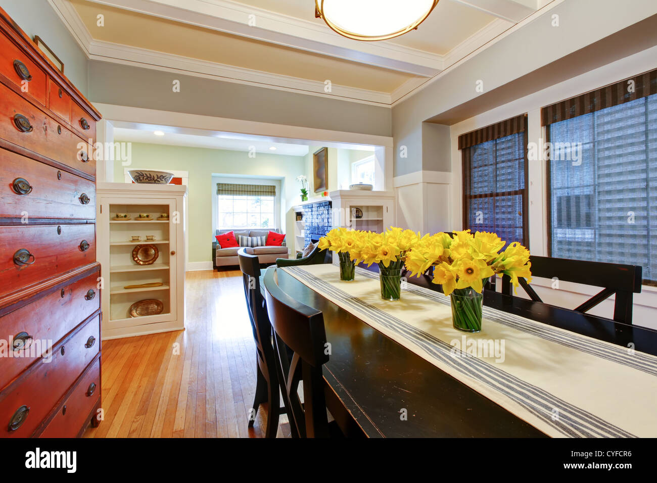 Dining room interior with large black table and wood dresser with grey blue walls. Stock Photo