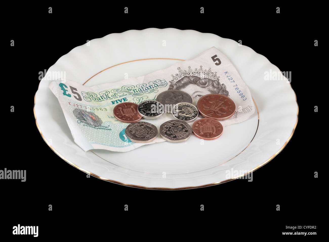 English Money on White Gold Rimmed Plate isolated on black background Stock Photo