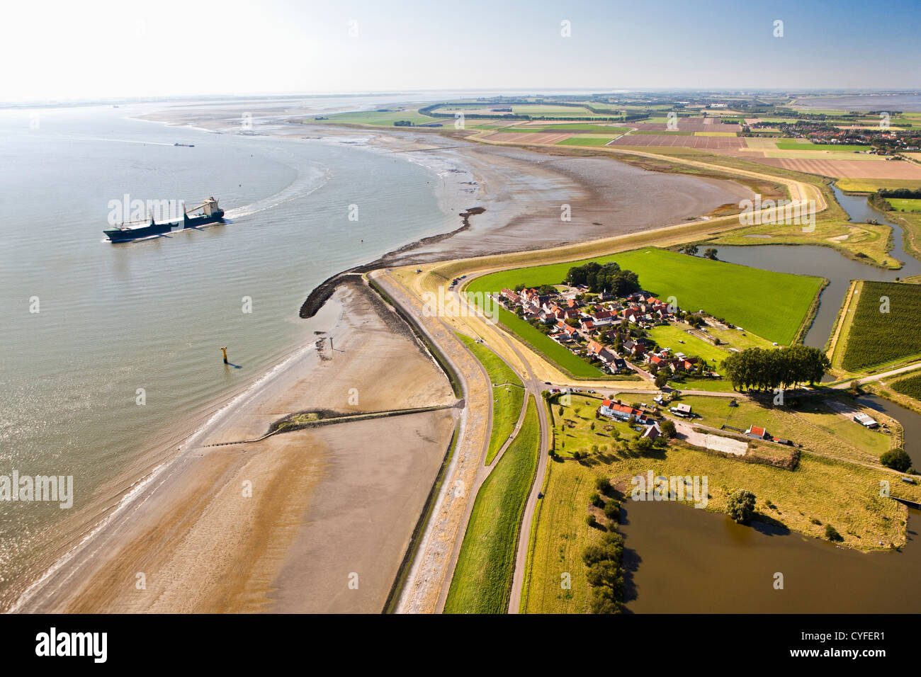 The Netherlands, Bath, View on village and the river Westerschelde. Cargo ship. Aerial. Stock Photo