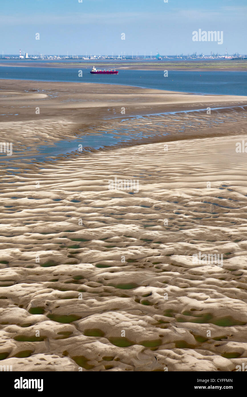 The Netherlands, Nieuw Namen, Cargo ship in Westerschelde river. Industrial area of Antwerp. Foreground tidal sandbank. Aerial. Stock Photo