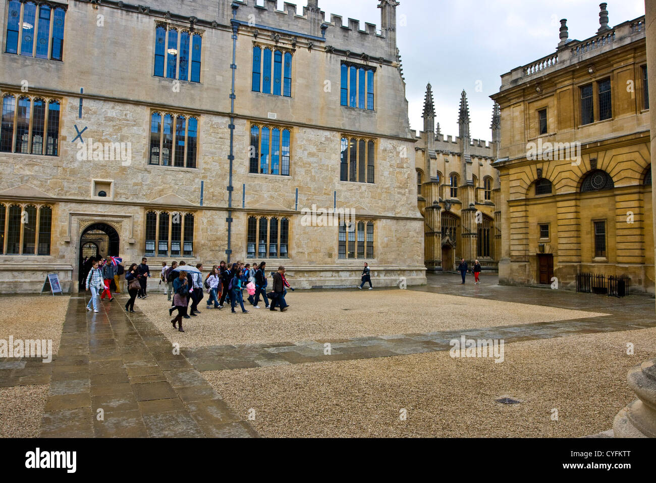 Tourists in the rain outside Grade 1 listed Bodleian Library and Sheldonian Theatre Oxford Oxfordshire England Europe Stock Photo