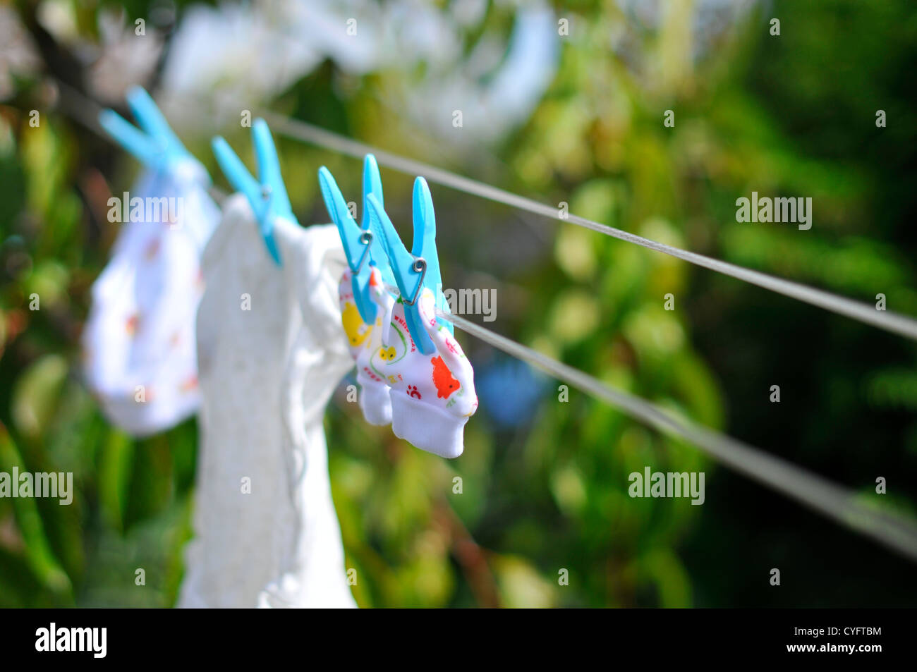 New born baby clothes hand on a washing line ready for a new arrival. Stock Photo