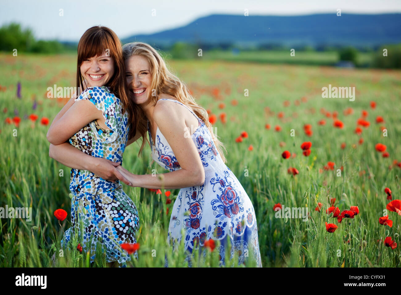 Two happy smiling girls in poppy field Stock Photo - Alamy