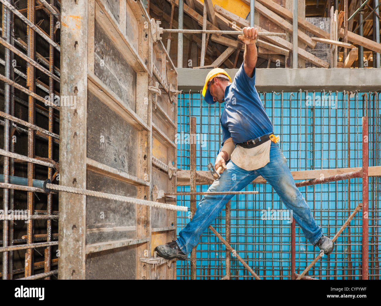 Construction worker balancing between scaffold and formwork frame Stock Photo