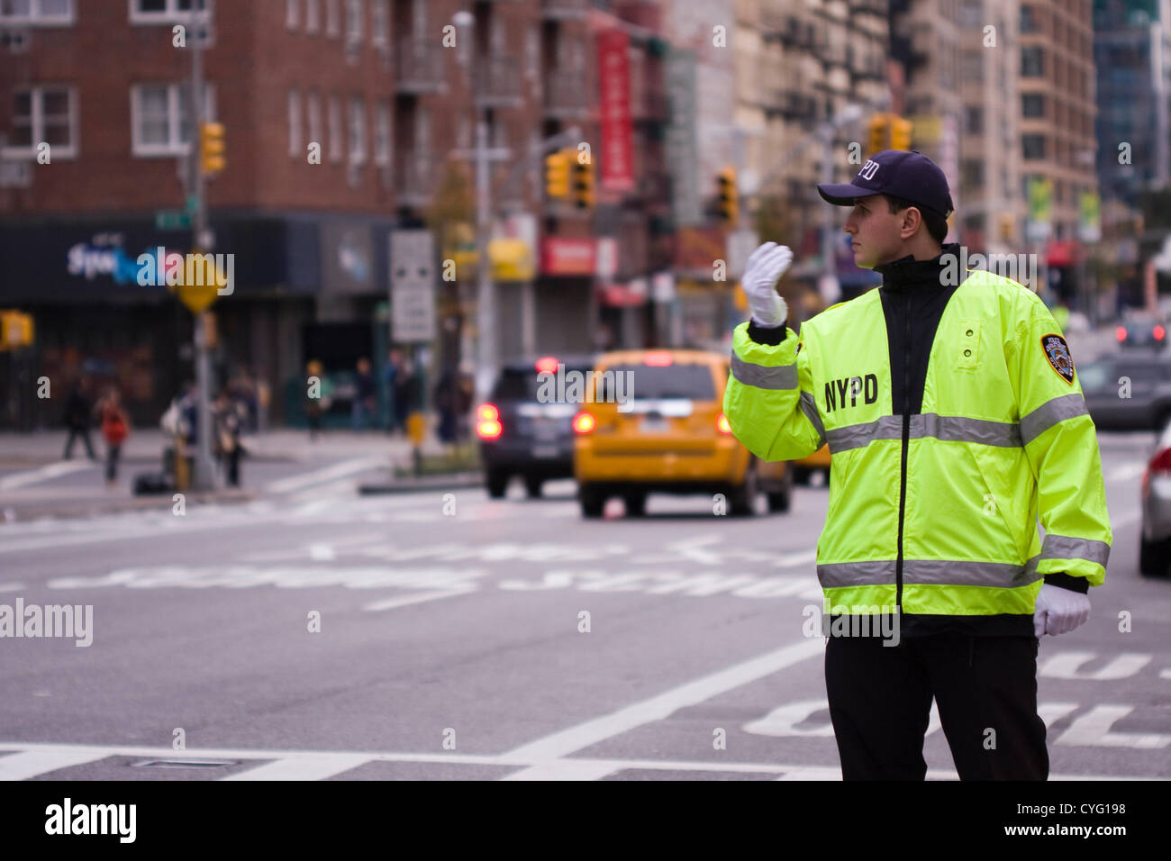 New York USA. November 1st 2012. NYPD Police Officer wearing reflective  jacket directs traffic on 23rd Street and 7th Avenue in New York City. The  traffic lights are dark due to a