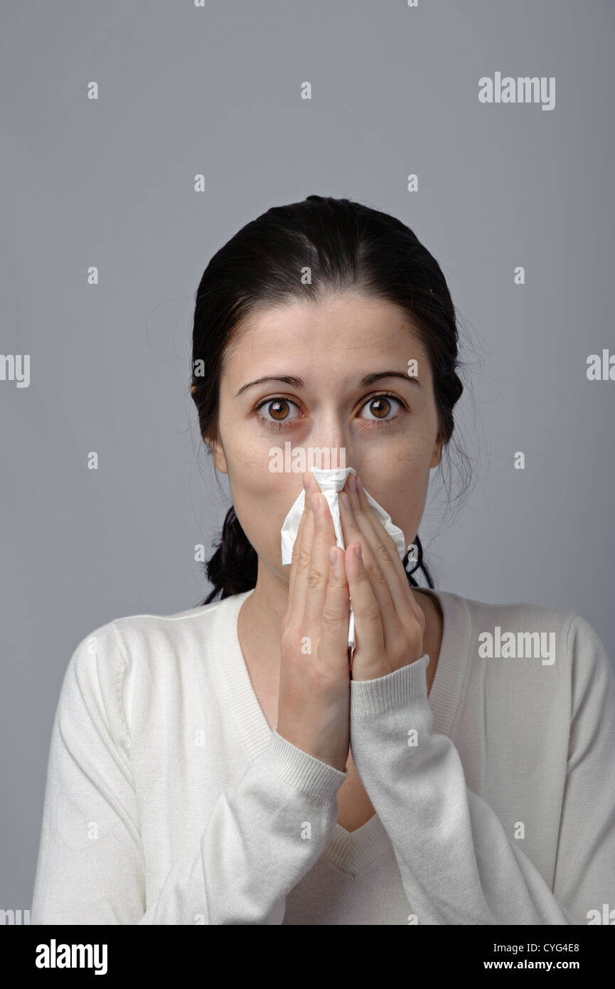Young woman blowing her nose with tissue paper Stock Photo Alamy