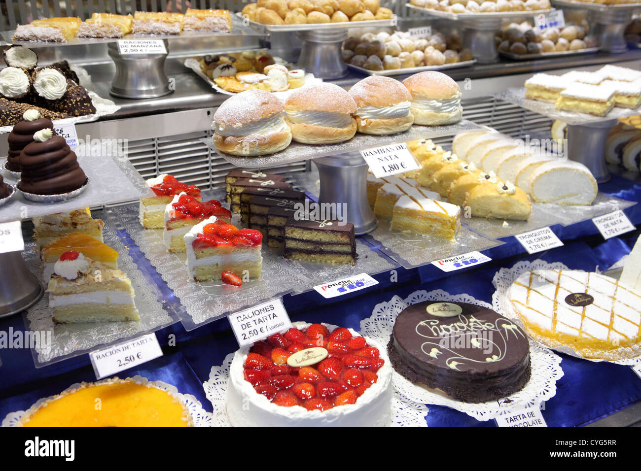 Sweet cream sponge pastry cakes for sale window traditional pasteleria bakery Madrid Spain Stock Photo