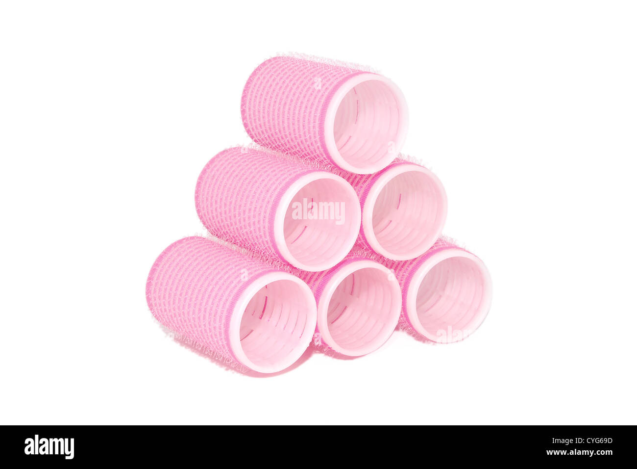 Six pink velcro rollers stacked in a pyramid, isolated on a white background Stock Photo