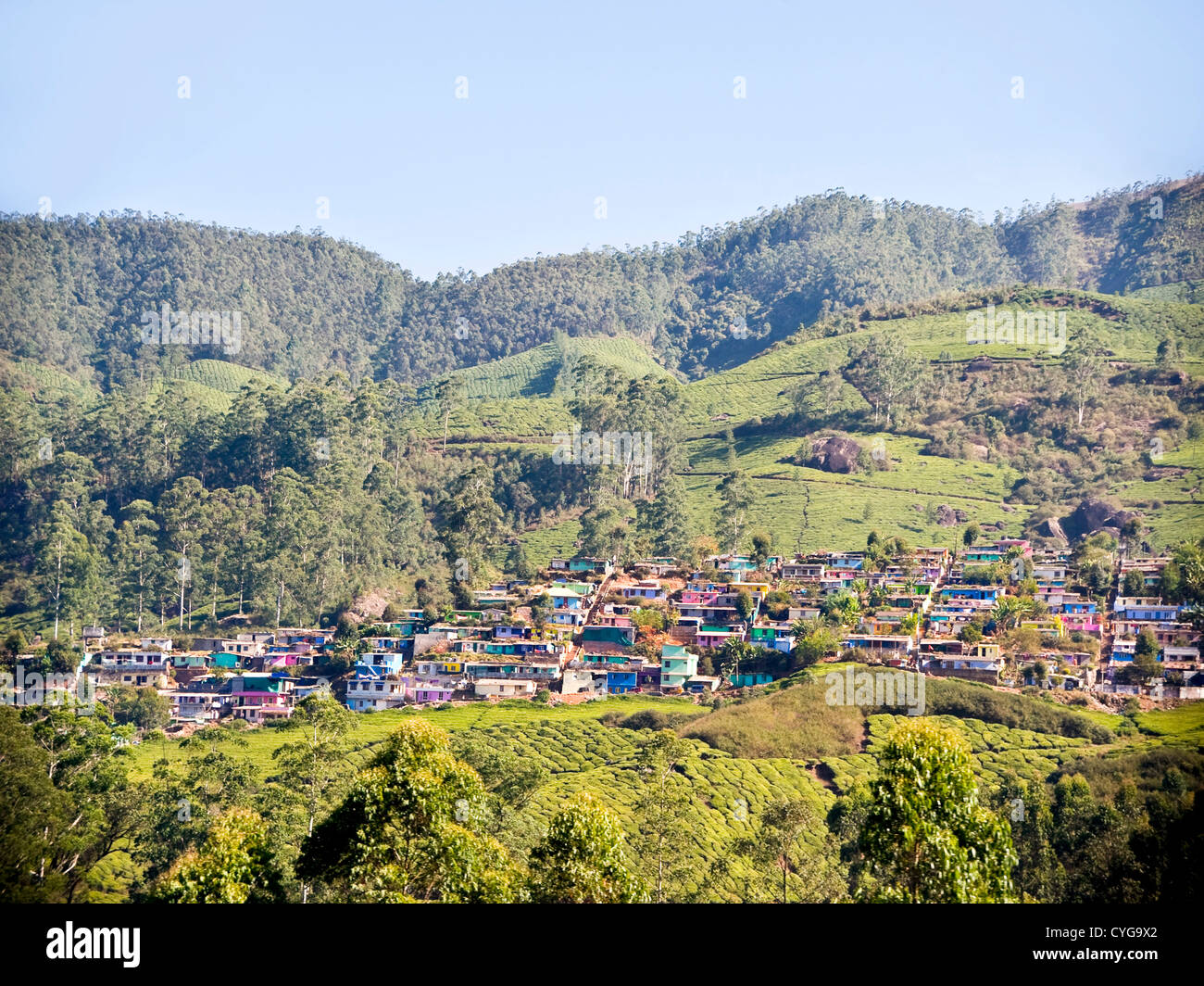Horizontal view of the colourful lowrise houses covering the slopes of the hills in Munnar, India. Stock Photo