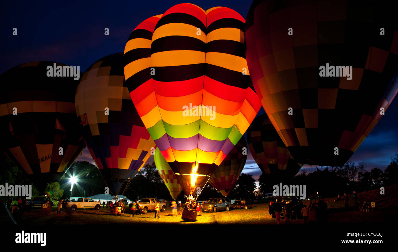 A number of Hot Air Balloons fire their burners lighting up the entire