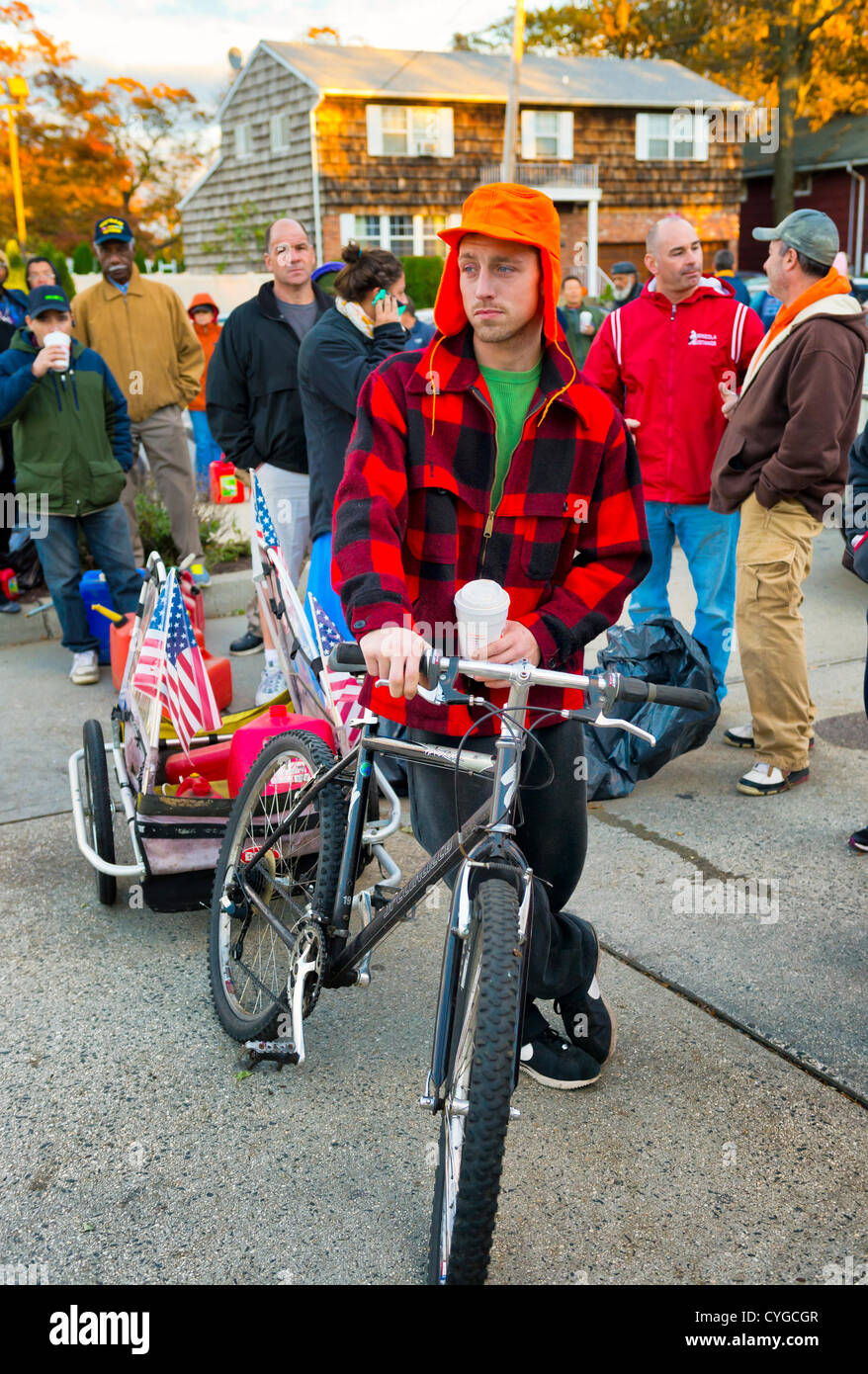 Nov. 3, 2012 - Merrick, New York, U.S. - JOHN GIBSON (wearing orange hat), of Merrick, used a bicycle cart to take gas containers to fill at Hess, one of the Long Island gas stations still open the Saturday after Hurricane Sandy battered this south shore area. Stock Photo