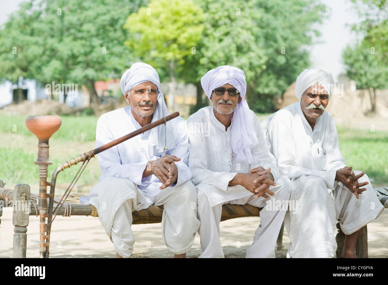 Three farmers sitting on a cot Stock Photo Alamy