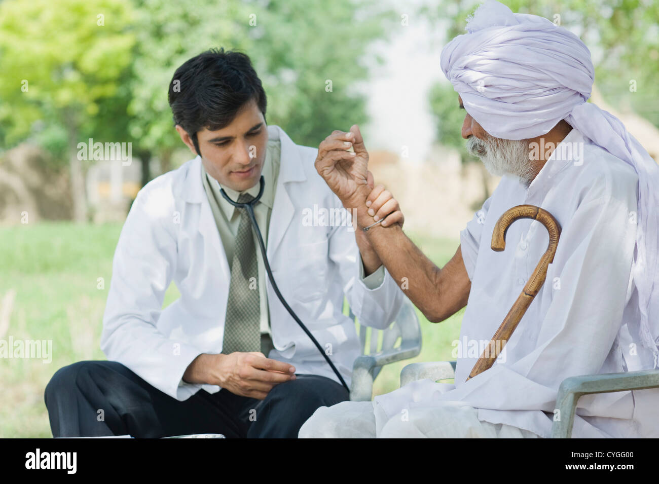 Doctor taking pulse of a farmer Stock Photo Alamy