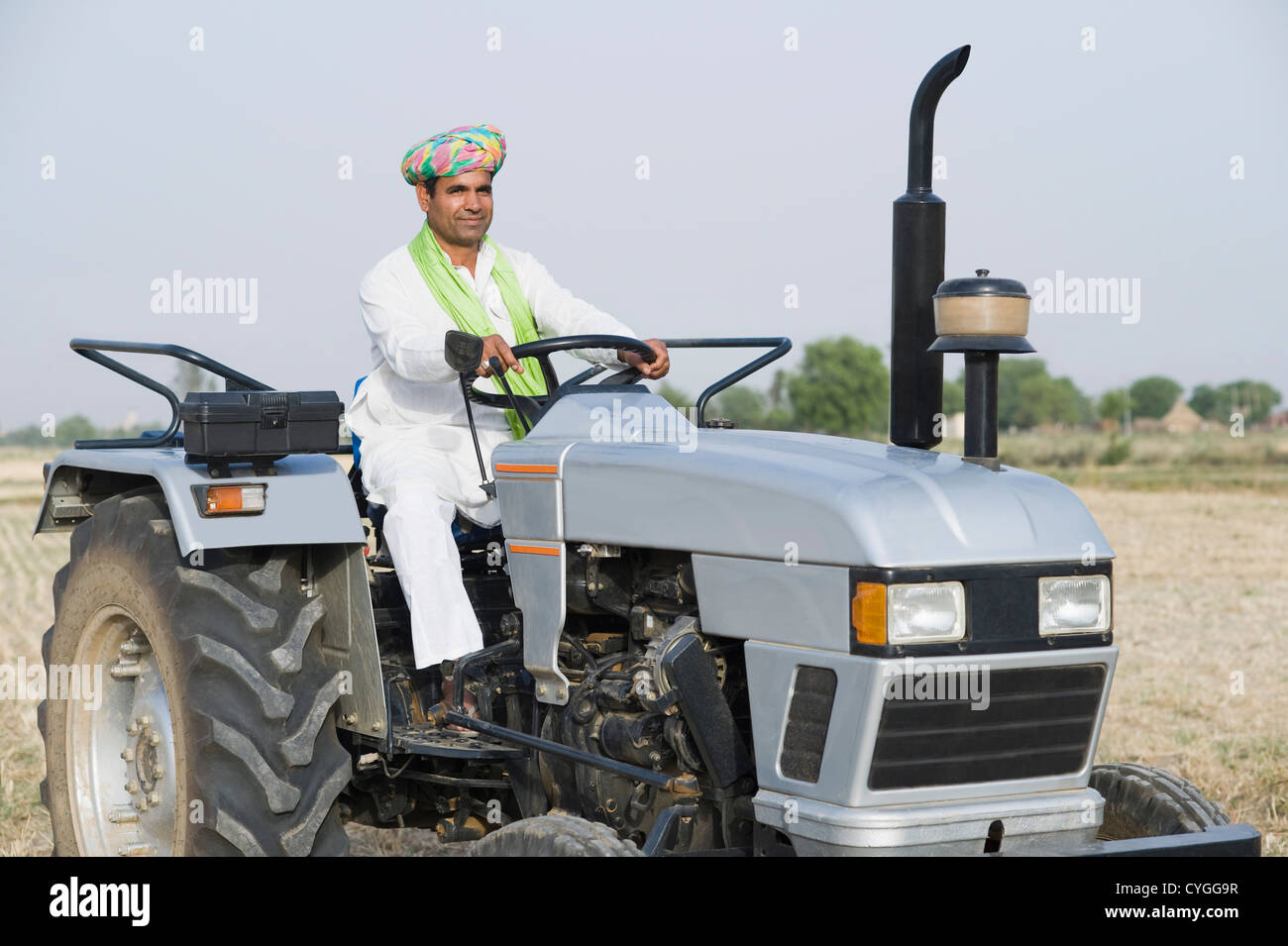 Farmer ploughing a field with a tractor Stock Photo - Alamy