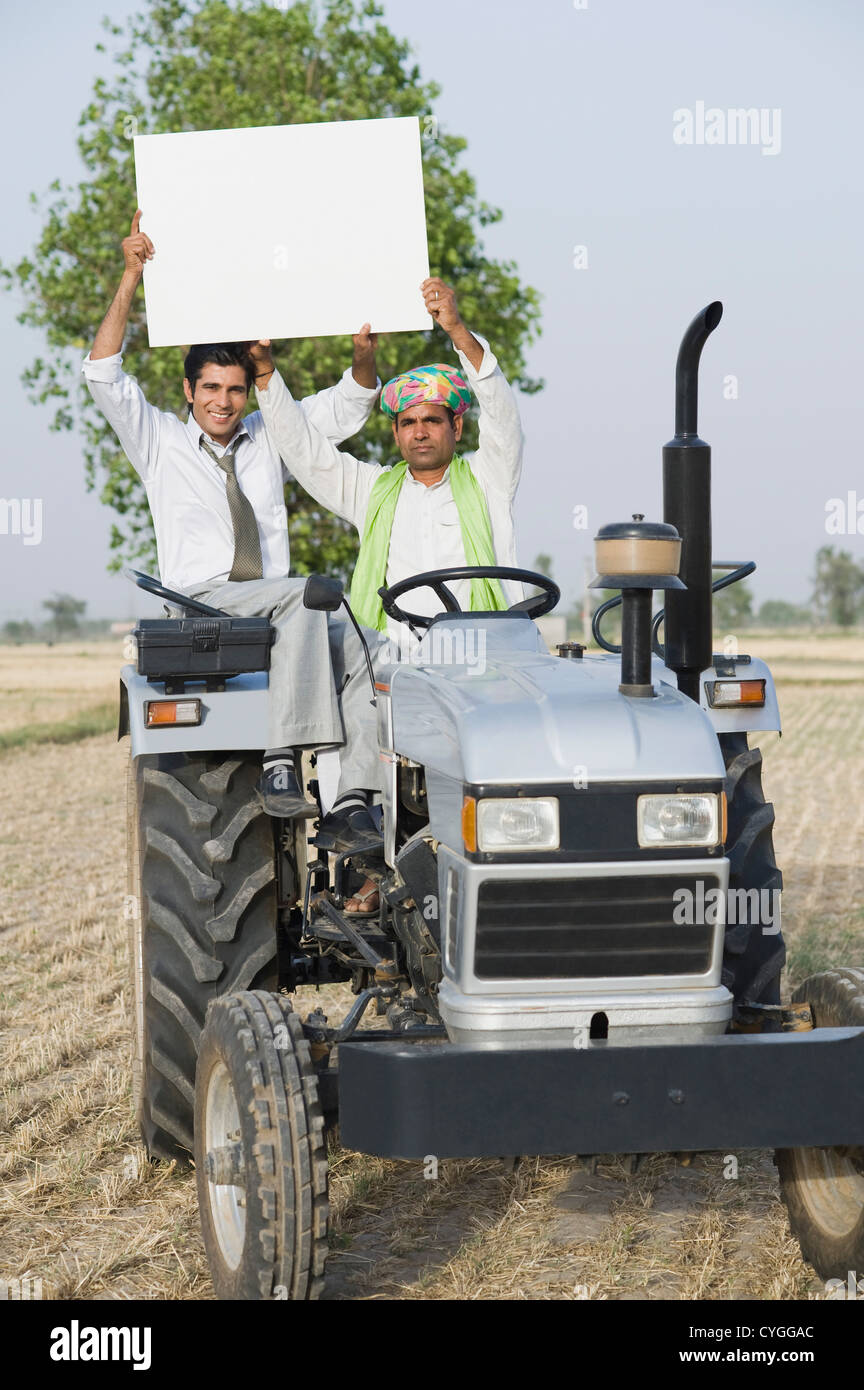 Financial advisor and a farmer showing a placard on a tractor Stock Photo Alamy