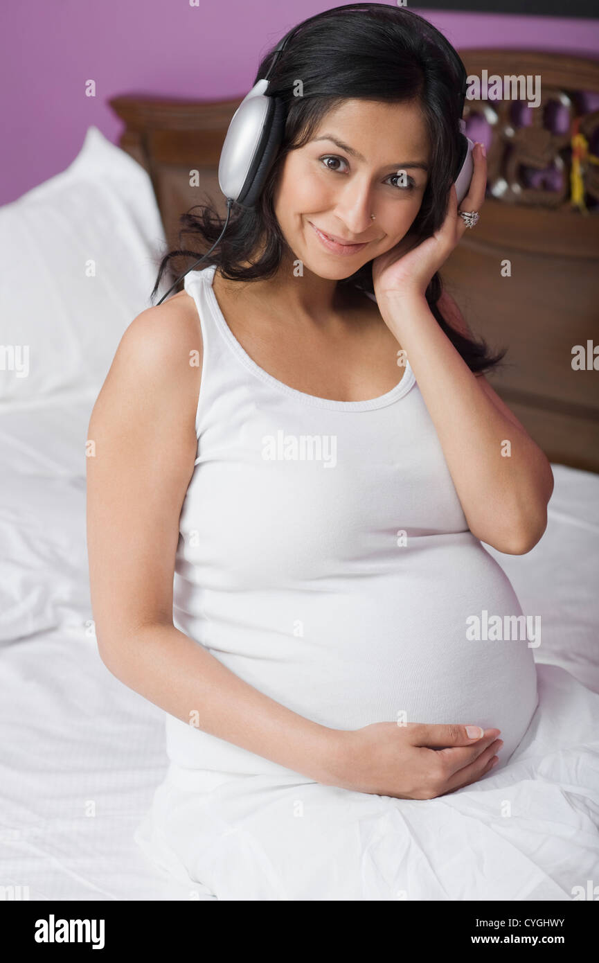 Pregnant woman listening to music Stock Photo - Alamy