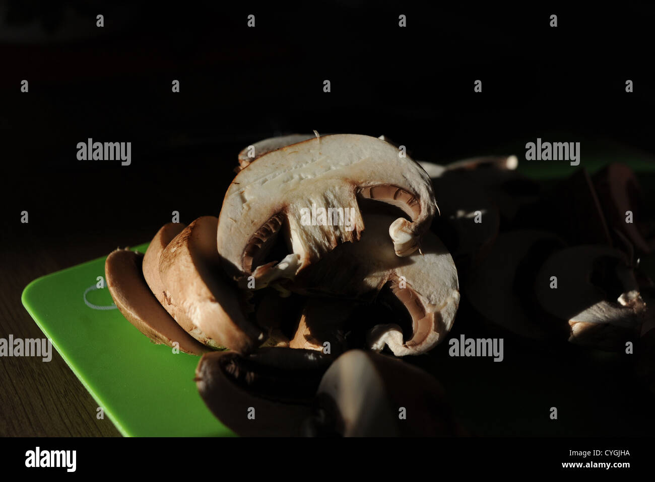 Fresh mushrooms being cut and sliced ready for cooking in kitchen Stock