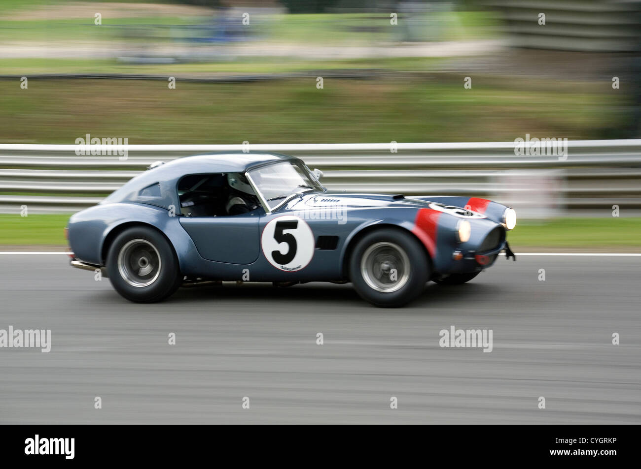 An AC Cobra hardtop classic racing car traveling fast on a racing circuit. Stock Photo