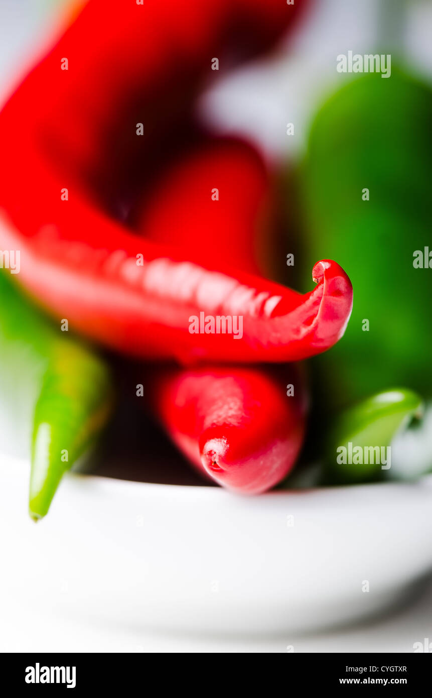 Green and red chili peppers in white bowl close up Stock Photo - Alamy