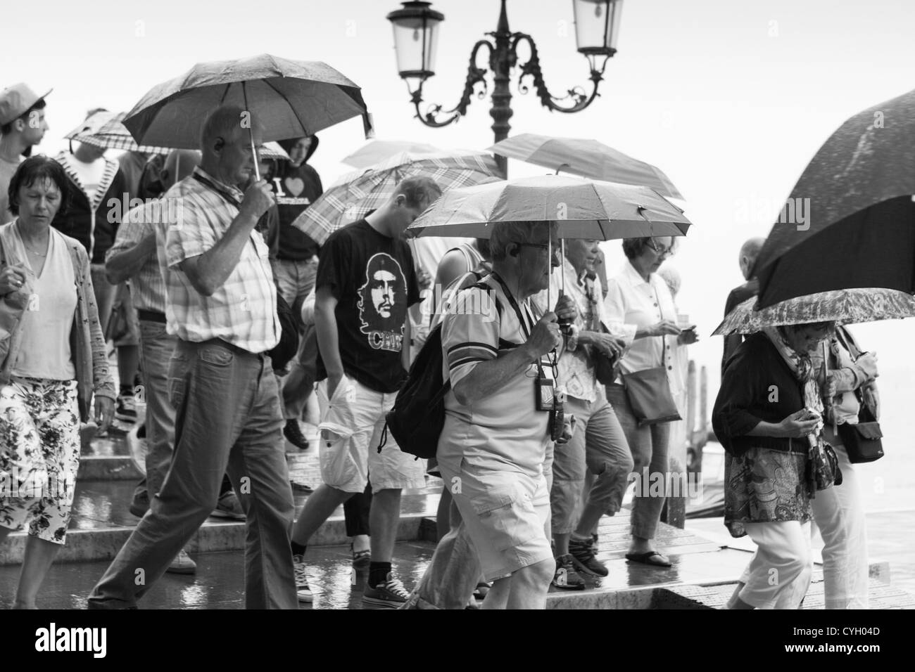 crowds of Tourists in the heavy rain. Venice waterfront. Italy Stock Photo