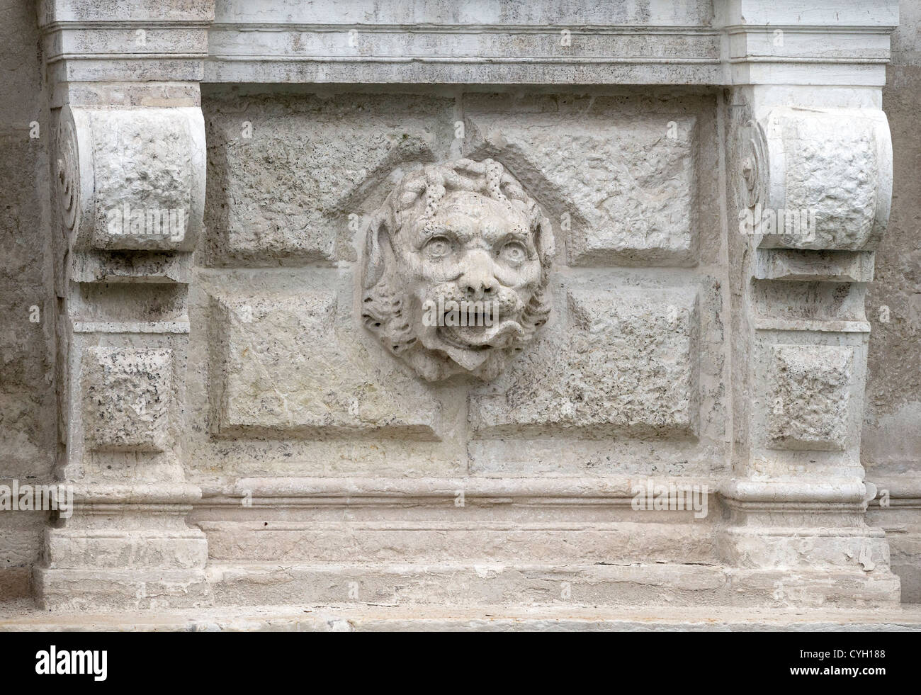 Carved lion's head on a rusticated stone background ornamenting the exterior wall of the Palazzo Rezzonico in Venice Stock Photo