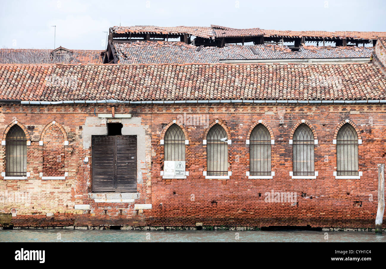 A somewhat dilapidated building at the Marco Polo Fornace glass factory in Murano, Venice, with Gothic arches Stock Photo