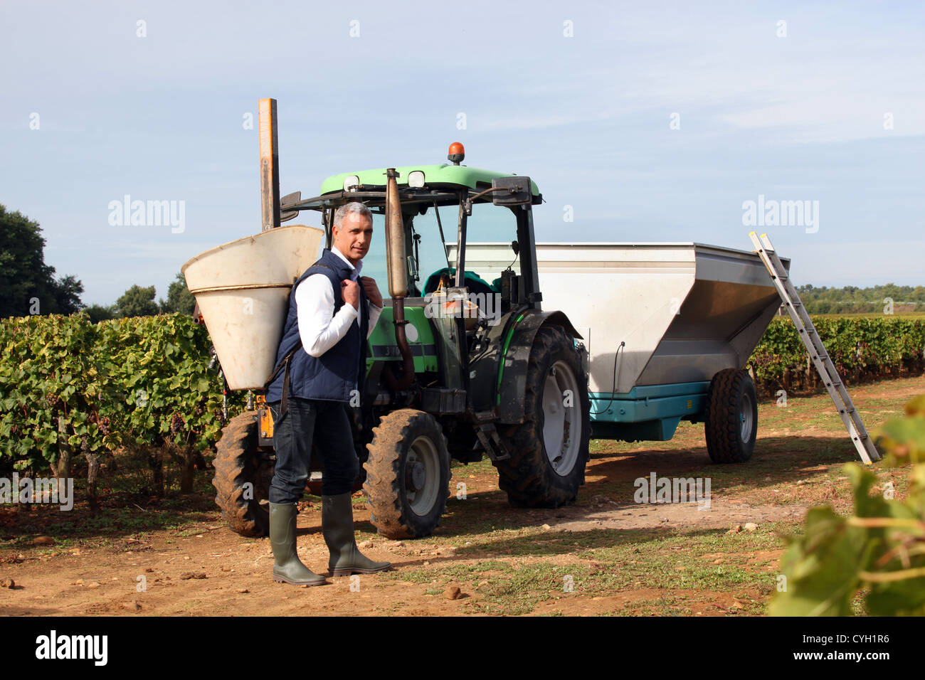 Farmer stood by tractor on vineyard Stock Photo - Alamy