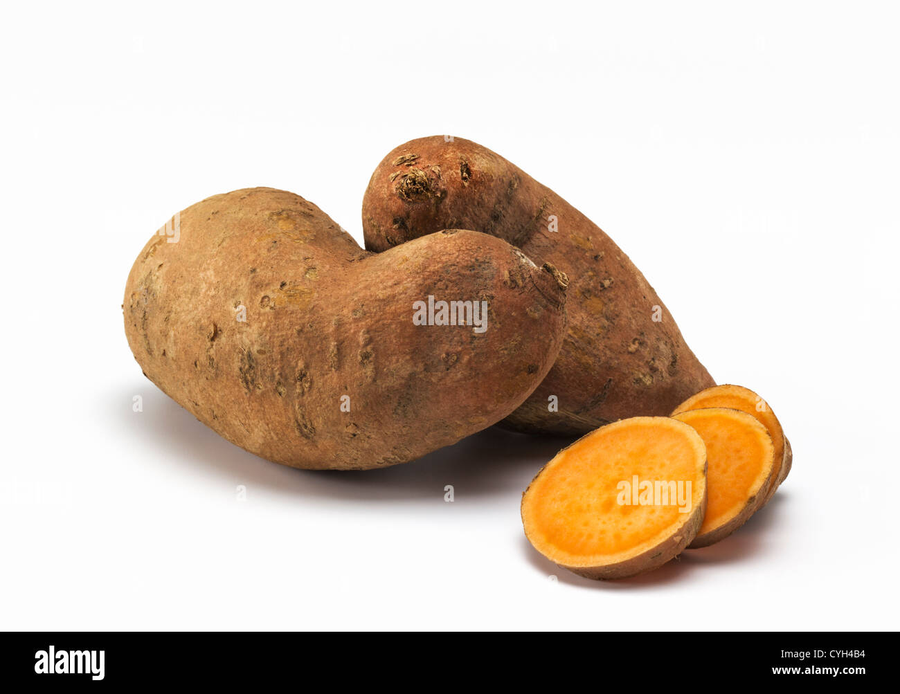Two whole sweet potatoes and sliced sweet potato Stock Photo