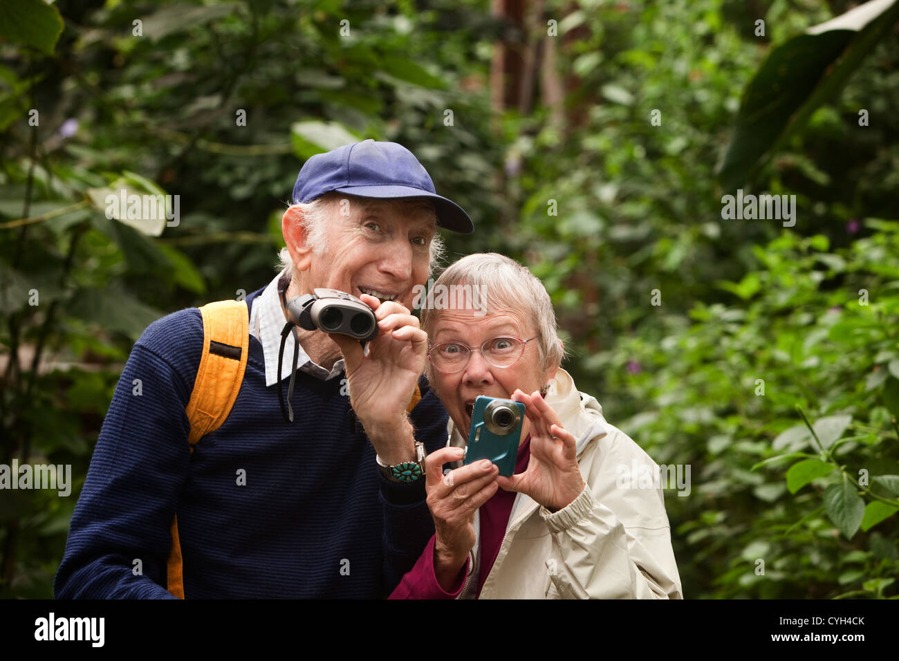 Two seniors with camera and binoculars in forest Stock Photo Alamy