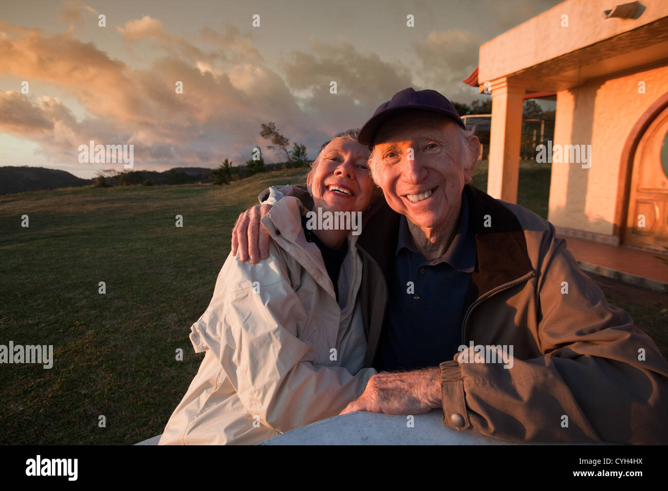 Loving elderly couple smiling at table in mountains Stock Photo