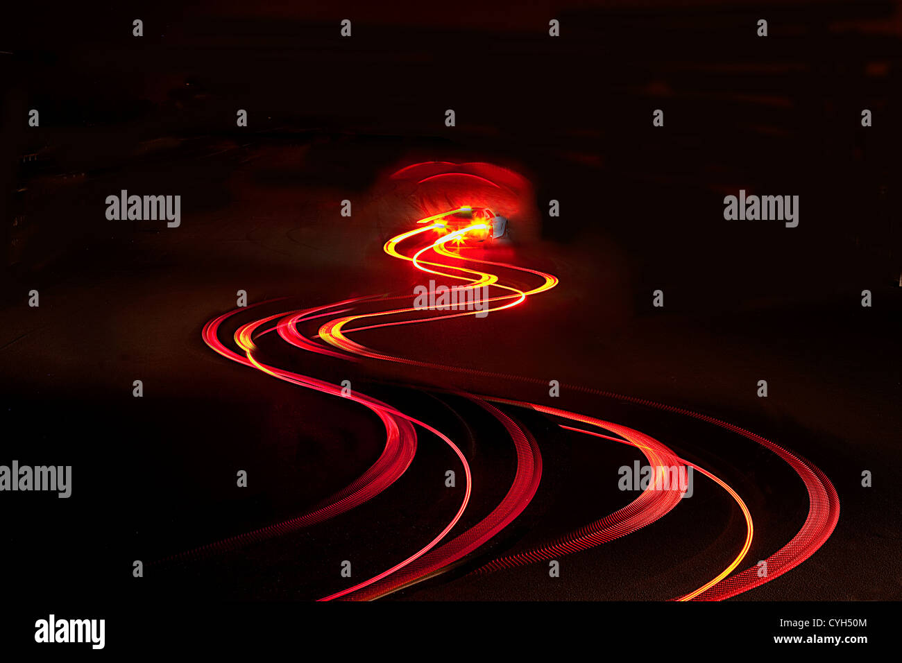 Car rear light trail on a country road at night. Stock Photo
