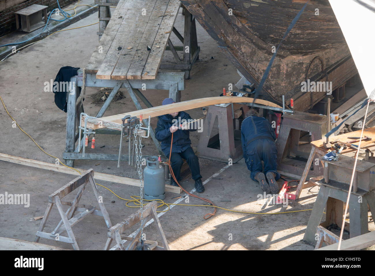 people working on the old russian frigate in dry dock for renovation Stock Photo