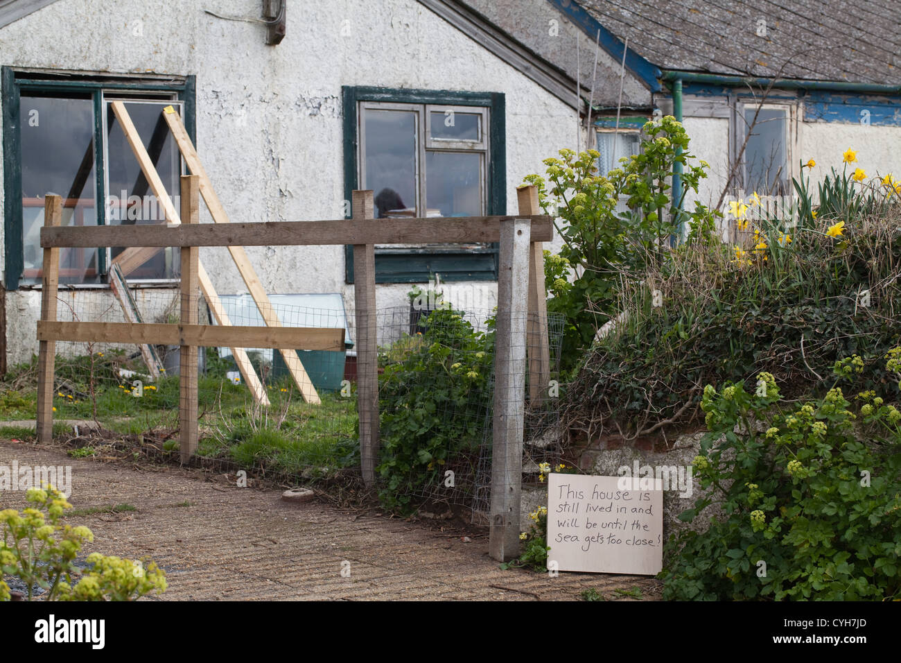 Happisburgh. Beach Road. Home not yet vacated. Resigned resident's hand written sign by gate. Next residence to be demolished. Stock Photo