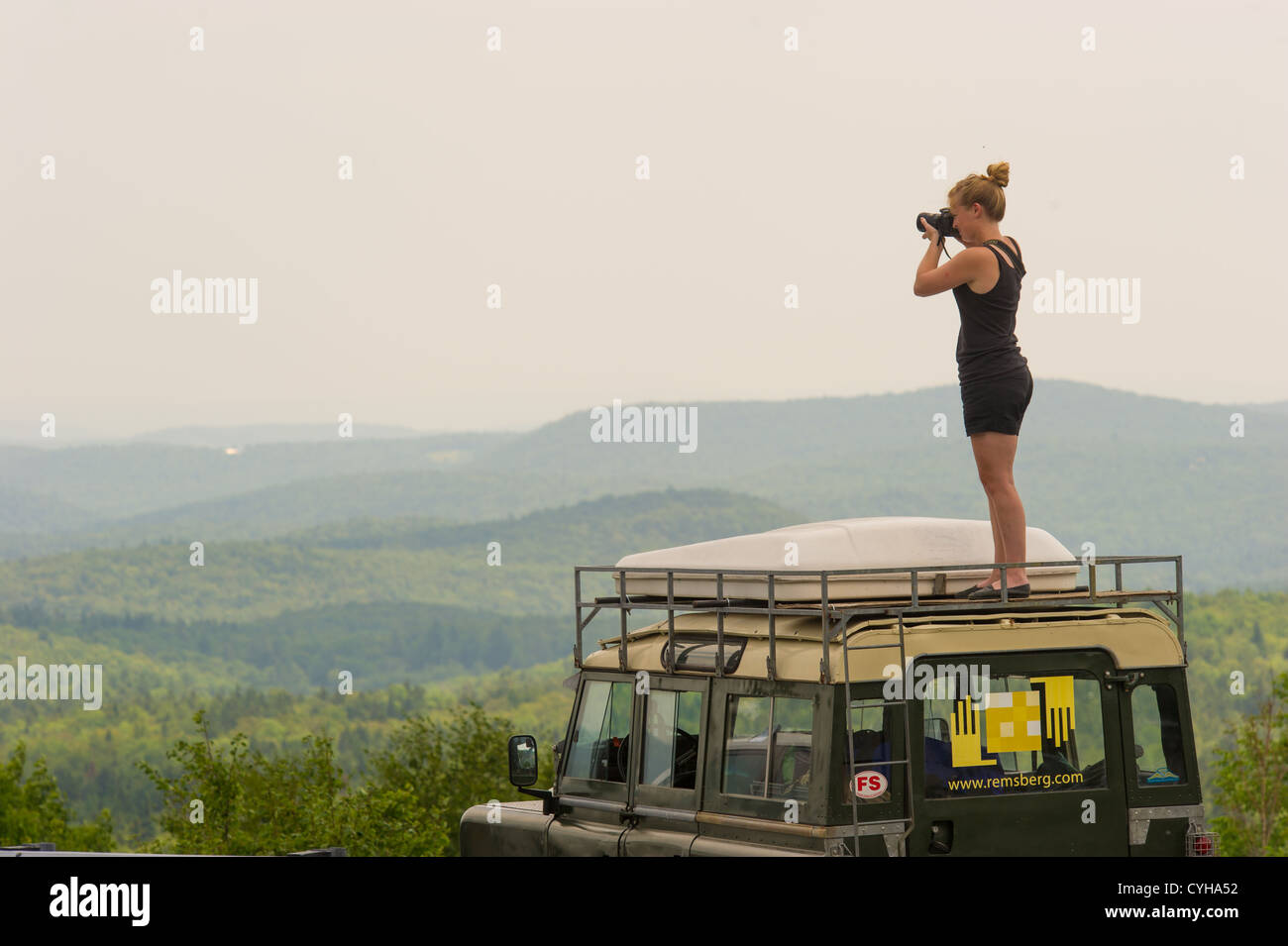 Woman photographing Vermont overlook of mountain range on New England road trip Stock Photo
