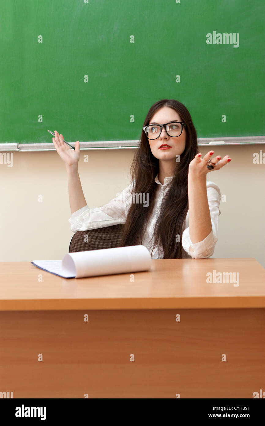 The teacher in the classroom on blackboard background Stock Photo - Alamy