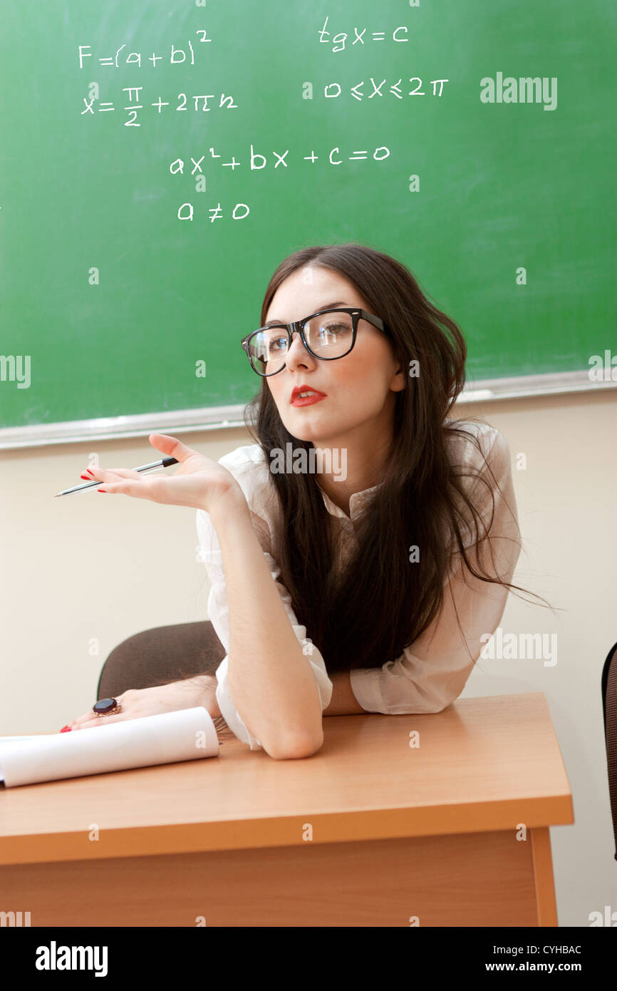 The teacher in the classroom on blackboard background Stock Photo Alamy