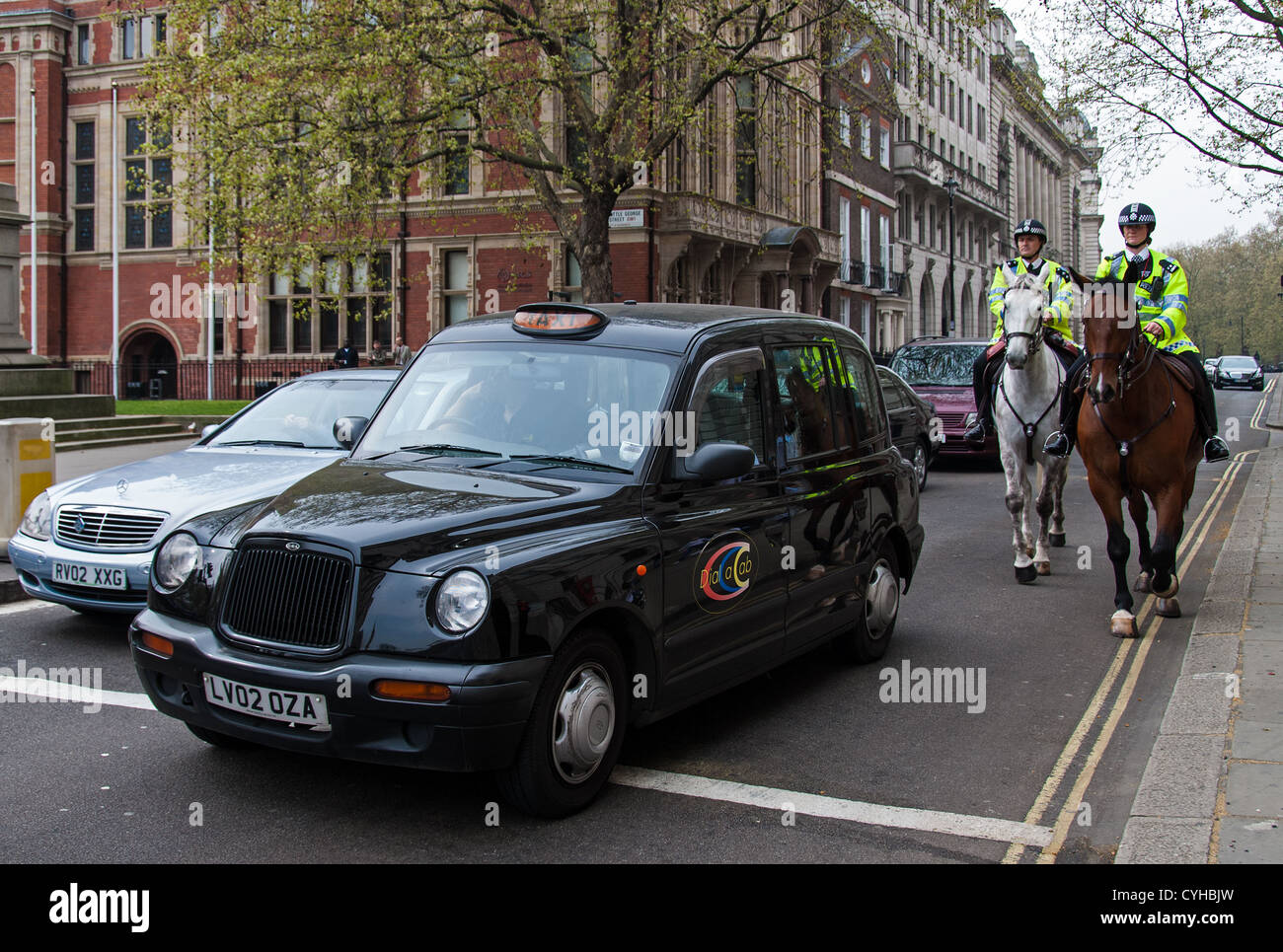 Black cab and mounted police officers on April 13, 2007 in London Stock