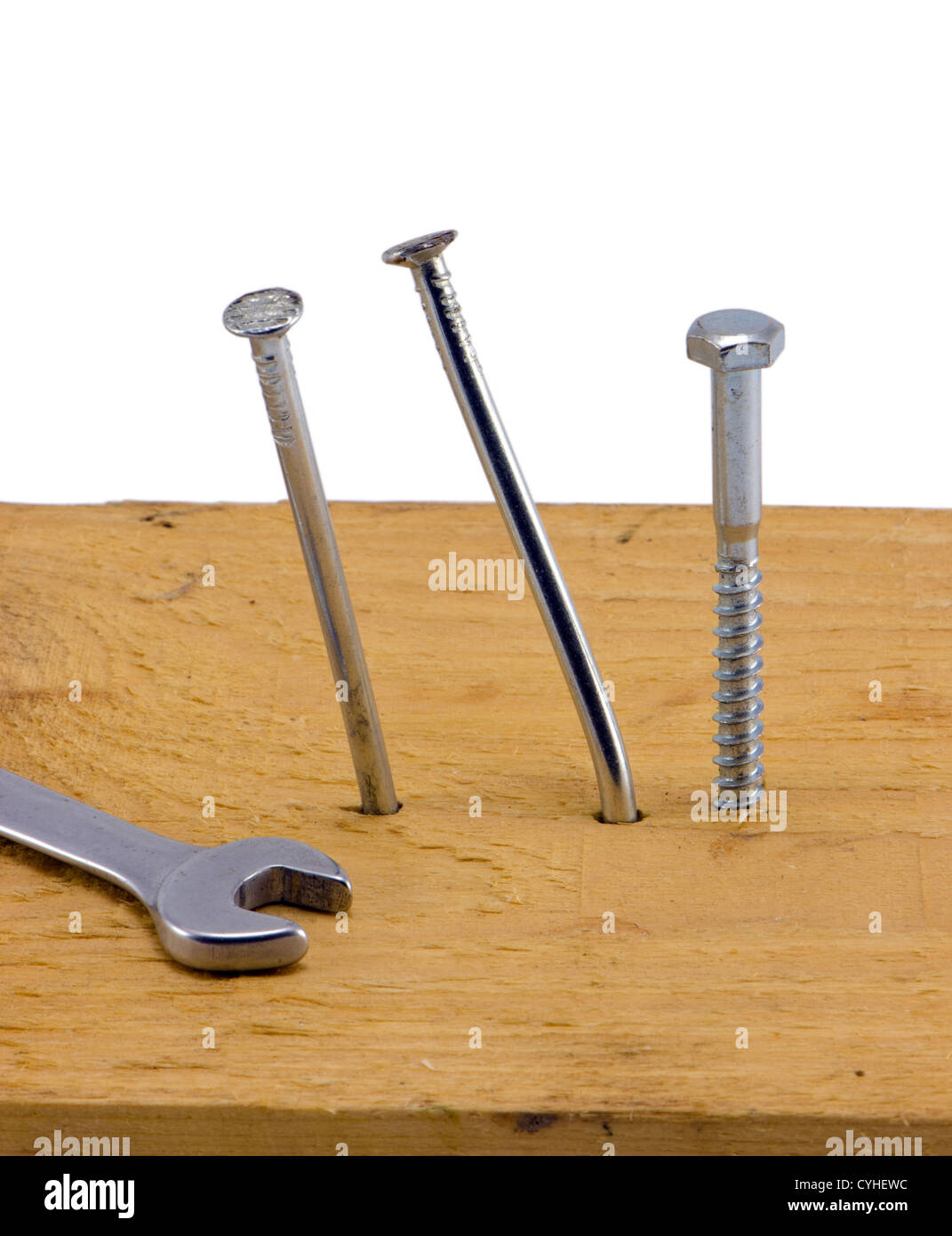 nails hammered to board bend and screw bolt with wrench tool head isolated  on white background Stock Photo - Alamy