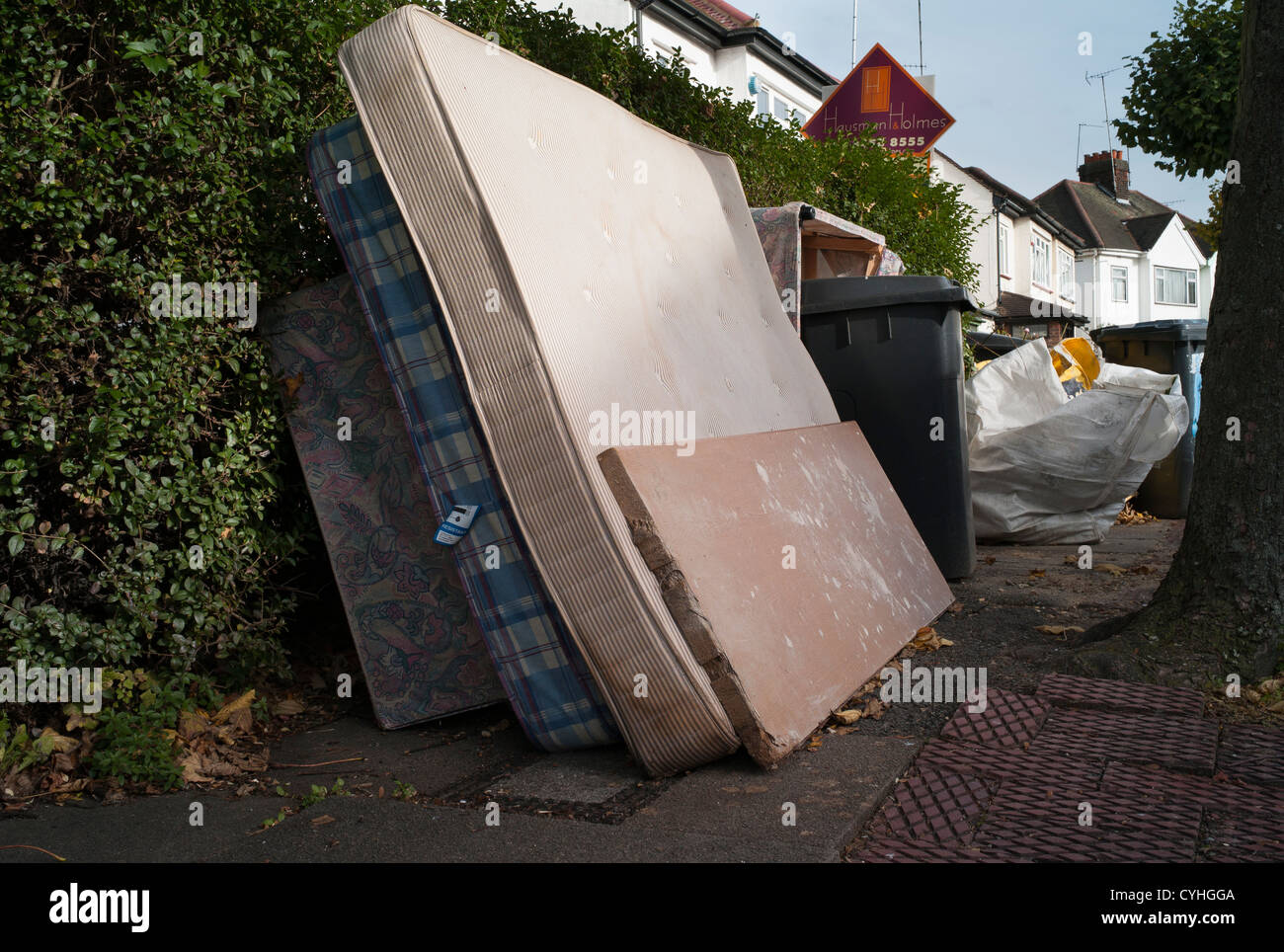 Fly tipping of old mattresses and builders rubble on street in Brent Cross Golders Green, London Stock Photo