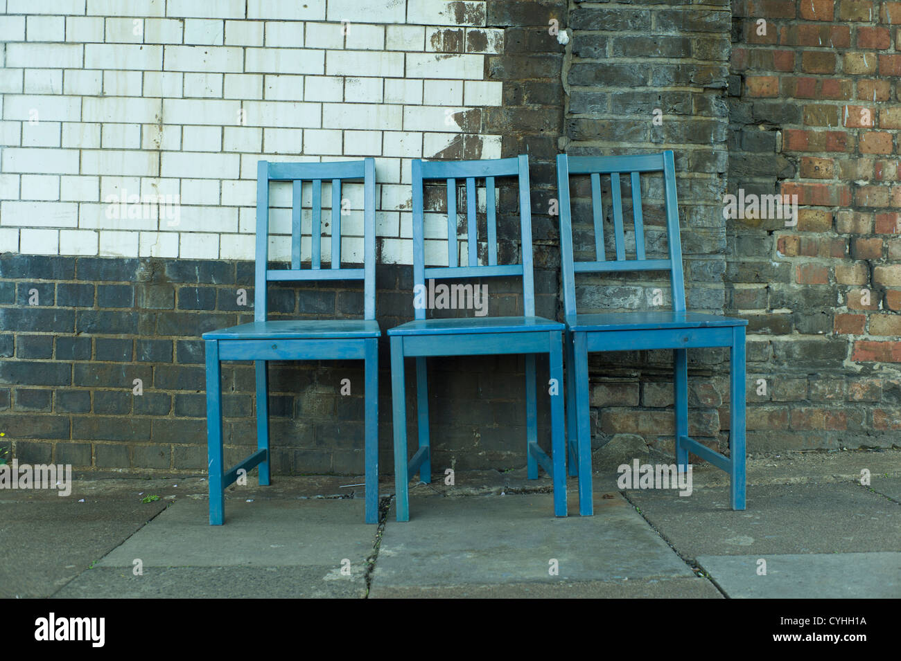 Fly tipping of three blue wooded kitchen chairs in street, Golders Green, London. Stock Photo